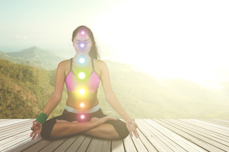 Woman meditating with colored chakra points